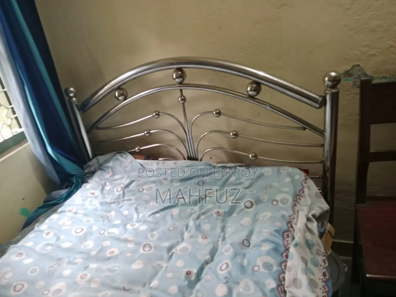 Two beds for sale: one wooden and one steel.