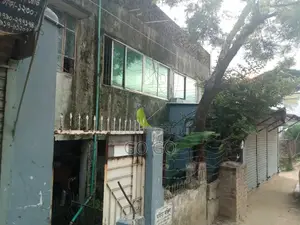 A 2-story building with 4 shops and vacant land beside it, total 4.32 Katha.