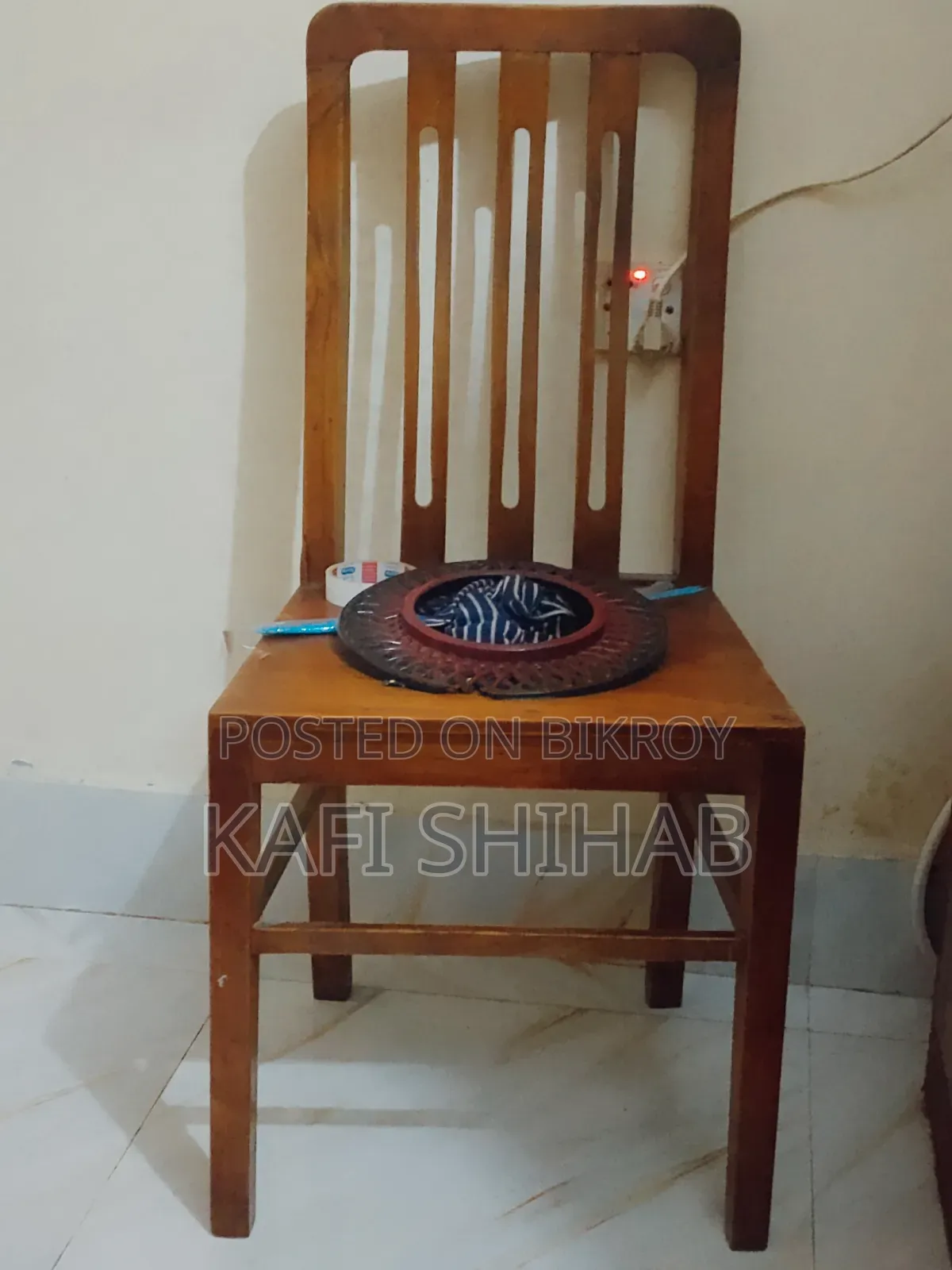 A teak wood chair is for sale at a low price.