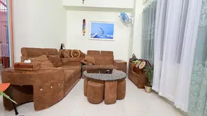 Sofa set with table and 5 stools for seating.