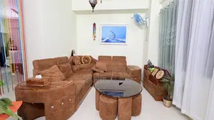 Sofa set with table and 5 stools for seating.
