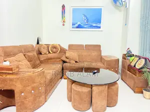 Sofa set with table and 5 stools for seating.