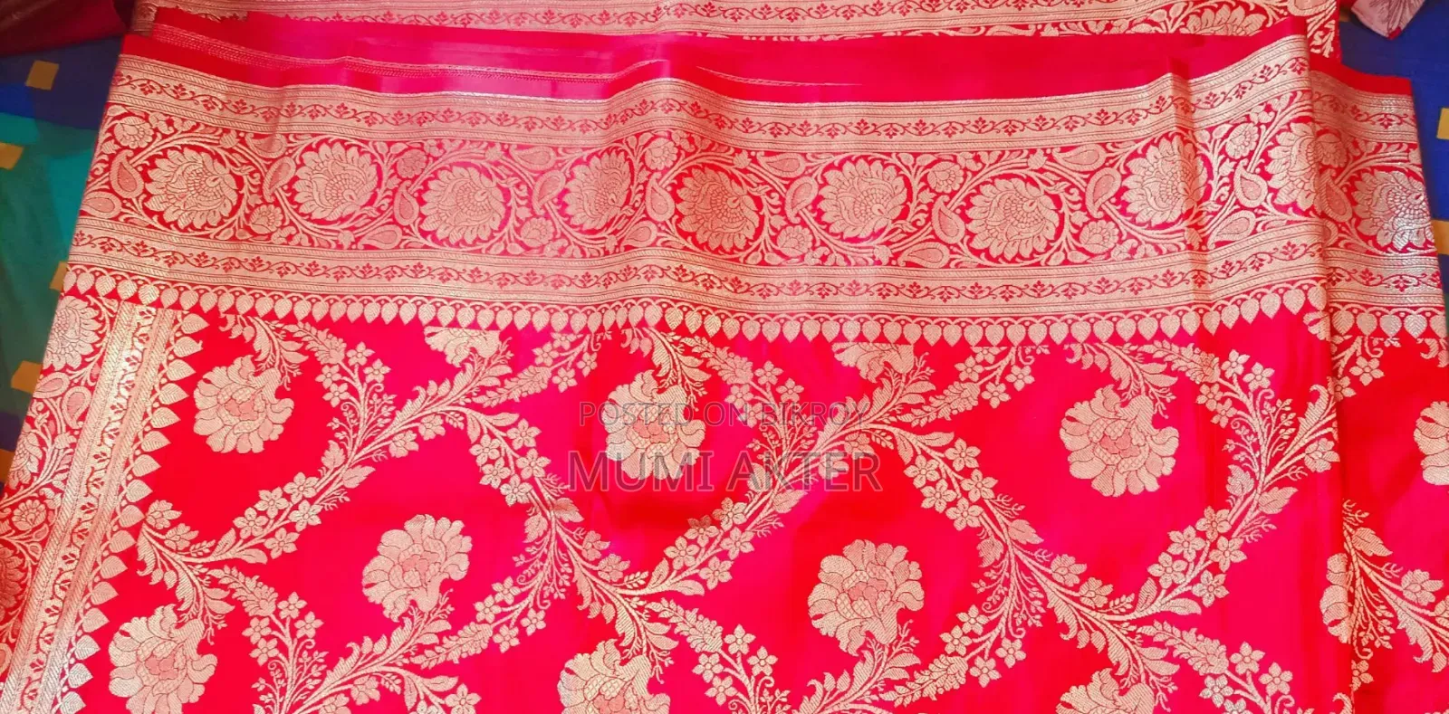 শাড়িটা লাল/রানি-লাল রঙের বেনারসি স্টাইলের শাড়ি,