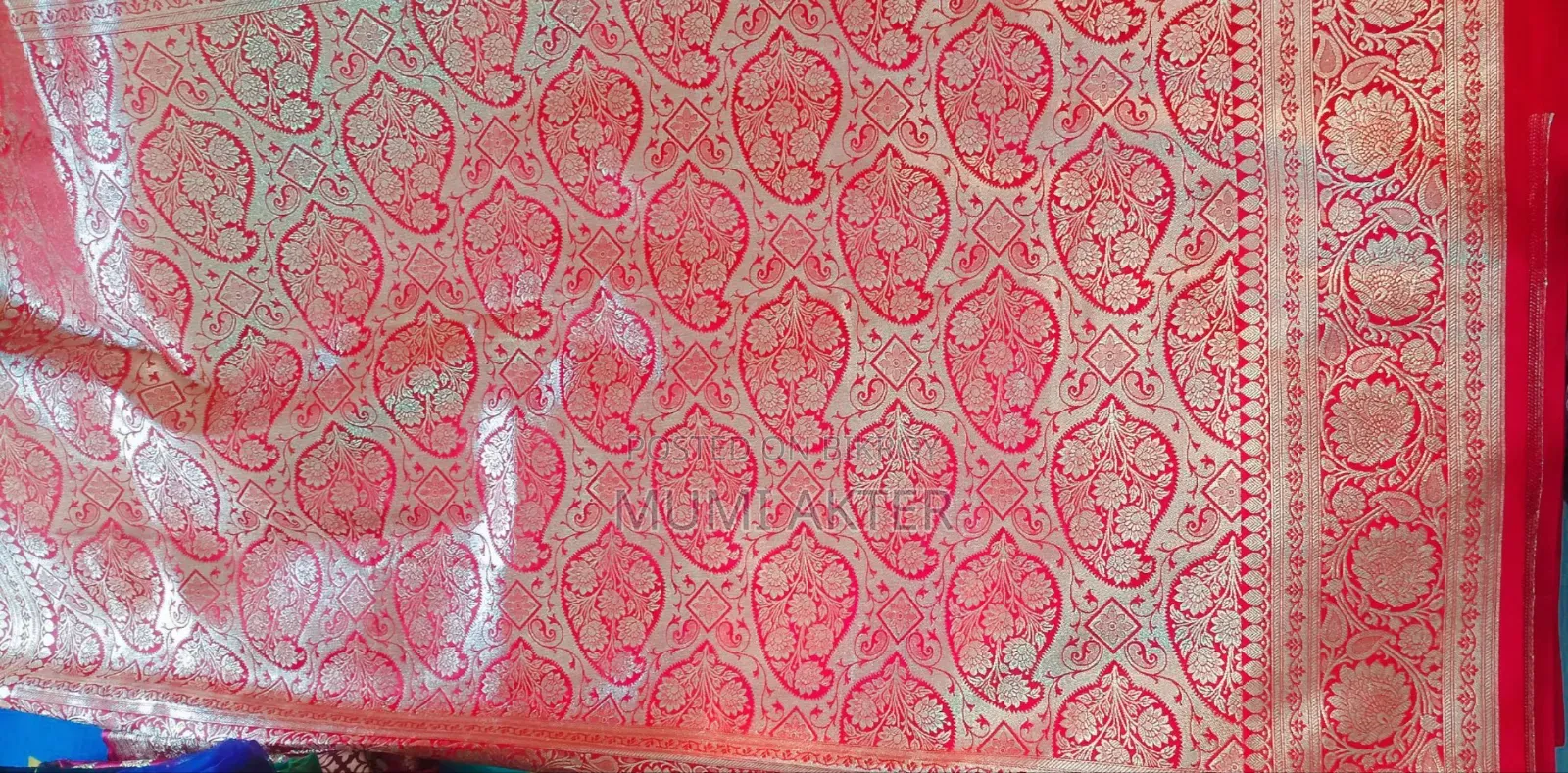 শাড়িটা লাল/রানি-লাল রঙের বেনারসি স্টাইলের শাড়ি,